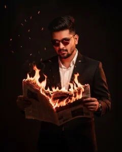 A man in a sharp black suit stands poised, As flames curl around the burning newspaper in dramatic glow